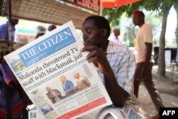 FILE - A man reads the local English-written daily newspaper "The Citizen" in Arusha, northern Tanzania, March 23, 2017.