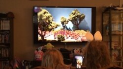 Los Angeles television editor Jason Smith's two young daughters watch an online lesson prepared by their grandfather, David Smith, a retired university professor.