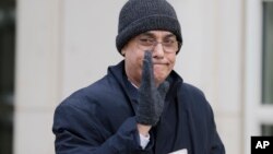 Former Peruvian soccer official Manuel Burga waves to reporters as he leaves federal court in the Brooklyn borough of New York, Dec. 26, 2017. 