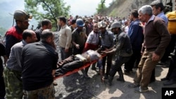 Para penambang dan tim SAR membawa seorang penambang yang terluka akibat ledakan di tambang batu bara dekat Azadshahr di Iran utara, 3 Mei 2017. (AP Photo/Tasnim News Agency, Mostafa Hassanzadeh)