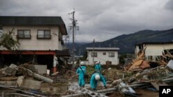 Pekerja menyurvei kerusakan di lingkungan yang hancur akibat Topan Hagibis Selasa, 15 Oktober 2019, di Nagano, Jepang. (Foto: AP / Jae C. Hong)