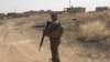 A Peshmerga fighter patrols a village retaken from IS militants during the latest offensive toward Mosul, June 6, 2016. (S. Behn/VOA)