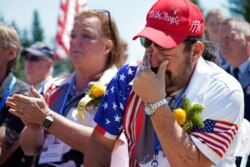 John Biernacki of Greenville, Texas, wipes tears during the unveiling of a monument to honor the military passengers of Flying Tiger Line Flight 739, May 15, 2021, in Columbia Falls, Maine.