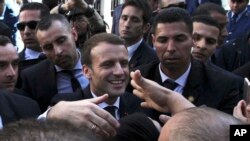 French President Emmanuel Macron shakes hands as he meets residents in Algiers, Wednesday, Dec.6, 2017. 