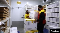 Karyawan di fasilitas penyimpanan dengan lemari dingin di pusat distribusi pos dan logistik Jerman, Deutsche Post DHL di Gurugram, India, 26 November 2020. (REUTERS / Anushree Fadnavis)