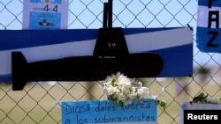 A bouquet of flowers and banners in support of the 44 crew members of the missing ARA San Juan submarine are placed on a fence outside an Argentine naval base in Mar del Plata, Argentina, Nov. 25, 2017. The banner below reads "God, give strength to the submariners." 