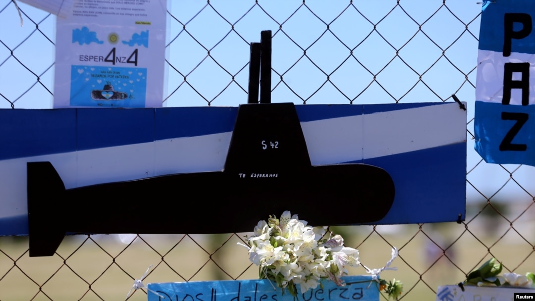 A bouquet of flowers and banners in support of the 44 crew members of the missing ARA San Juan submarine are placed on a fence outside an Argentine naval base in Mar del Plata, Argentina, Nov. 25, 2017. The banner below reads "God, give strength to the su