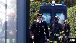 Итальянские полицейские и пожарные на месте взрыва у посольства Швейцарии. Рим. Италия. 23 декабря 2010 года