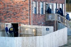 FBI and ATF agents investigate a home, Dec. 26, 2020, in Nashville, Tenn., after an explosion the day before damaged buildings and left several people injured.