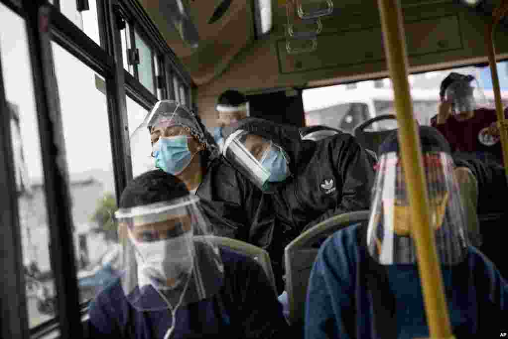 Commuters wearing protective face masks and face shields travel on a public bus in Lima, Peru, Wednesday, July 22, 2020