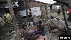 Orang-orang Rohingya menghabiskan waktu di tempat penampungan yang hancur di Sittwe, Rakhine.