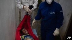 FILE - An emergency worker carries Jose Rocha on a hammock to a field hospital treating suspected COVID-19 patients in Manacapuru, Amazonas state, Brazil, June 1, 2020. Rocha was having difficulty breathing. 