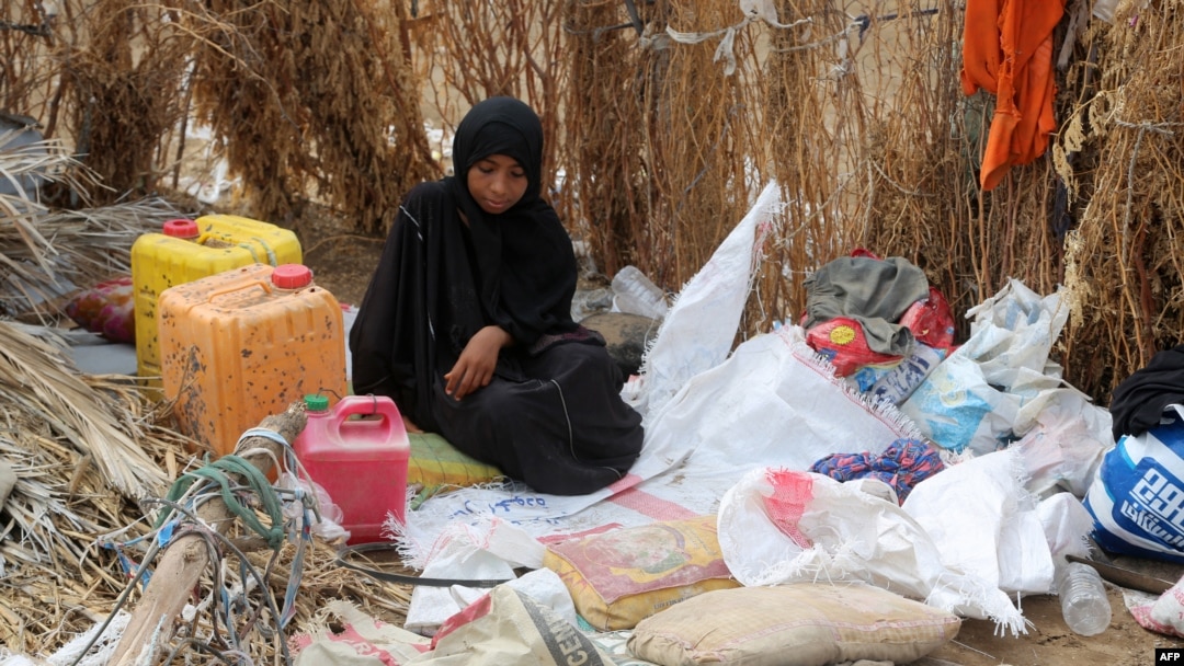 FILE - A Yemeni woman sits in the remains of a home in a neighborhood ravaged by Tropical Cyclone Sagar, in the port city of Hodeidah, Yemen, May 19, 2018