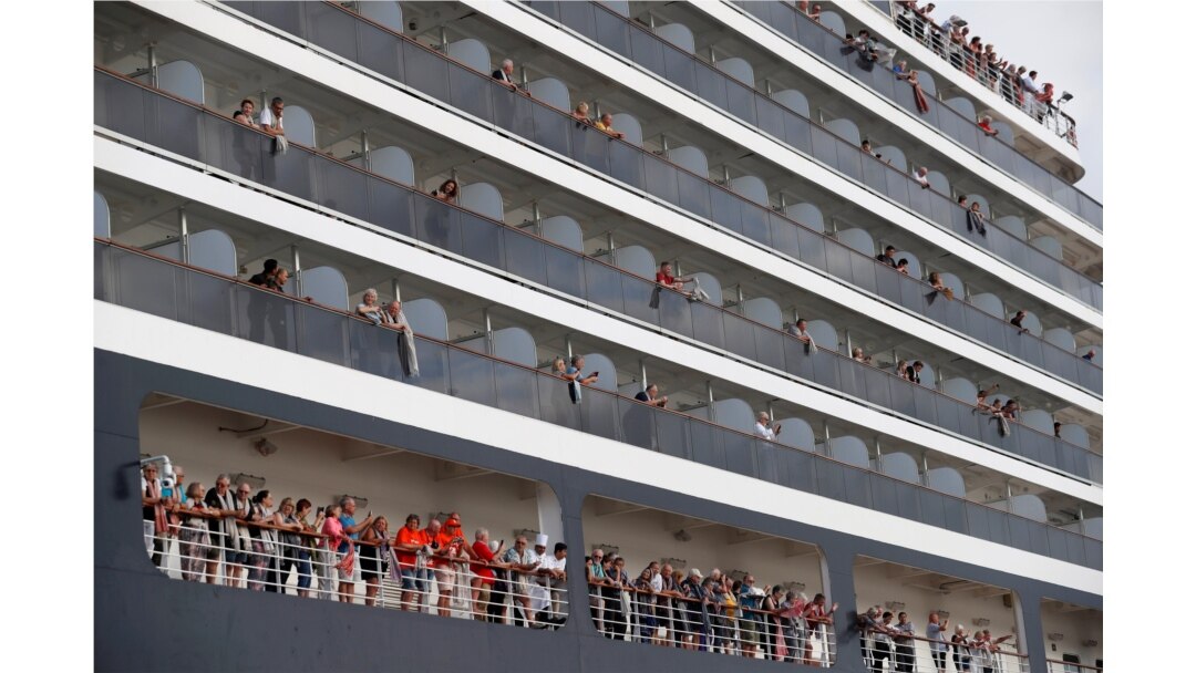 FILE - Passengers prepare to leave MS Westerdam, a cruise ship that spent two weeks at sea after being turned away by five countries over fears that someone aboard might have the coronavirus, as it docks in Sihanoukville, Cambodia, Feb. 14, 2020.
