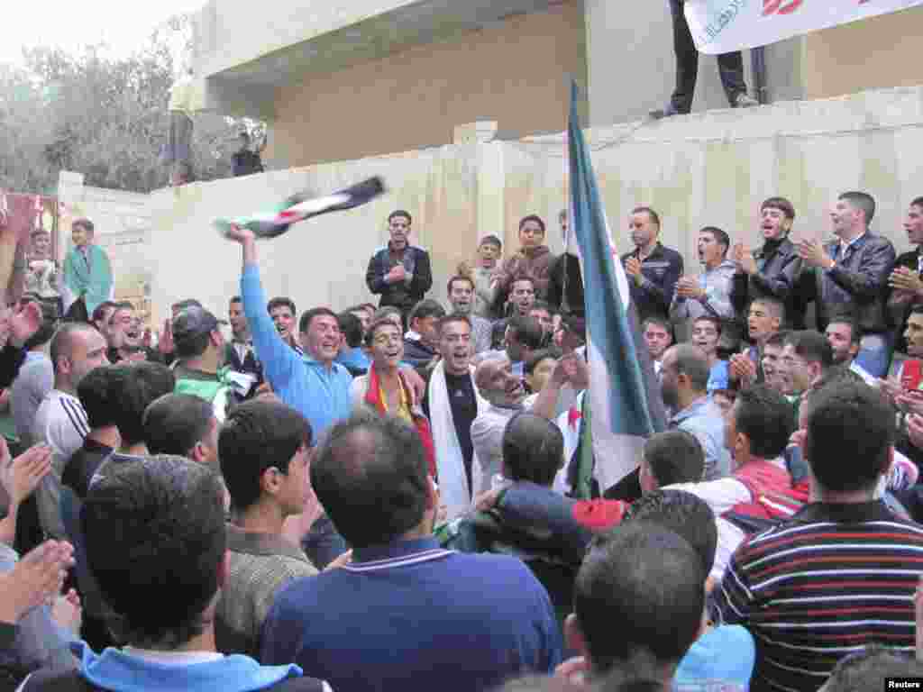 Demonstrators hold opposition flags during a protest against Syria's President Bashar al-Assad, after Eid al-Adha prayers, Dara, Syria, October 26, 2012.