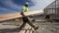 Construction worker Miguel Fonseca carries lumber as he works on a house frame for a new home, Nov. 16, 2012, in Chula Vista, Calif.