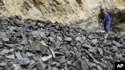 A worker shovels coal at coal mine owned by Puda Coal Inc. in Pinglu, Shanxi province. Puda Coal Inc, an independent coking coal producer in northern China's Shanxi province, (File)