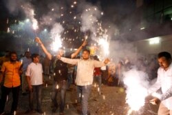 Supporters of India's ruling Bharatiya Janata Party light firecrackers and celebrate the government revoking Kashmir's special status, in Lucknow, India, Aug. 6, 2019.