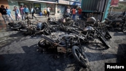 Sisa kendaraan yang terbakar, dibakar oleh para pengunjuk rasa, Selasa (23/1), yang memprotes penayangan film Bollywood, 'Padmaavat', terlihat are seen outside a multiplex in Ahmedabad, India Jan. 24, 2018.