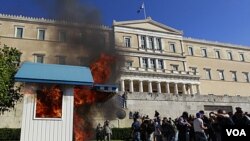 Los manifestantes incendian la caseta de un guardia frente al Parlamento en Atenas.