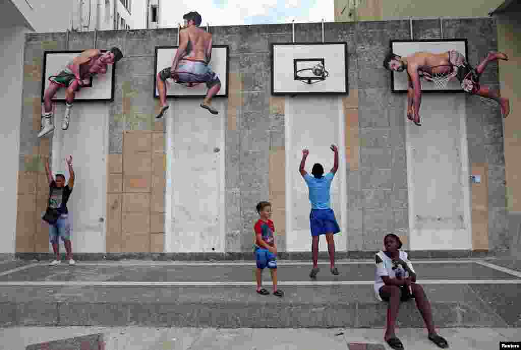 Children play basketball with an installation by Spanish artists Martin and Sicilia during the 13th Havana Biennial, in Havana, Cuba.