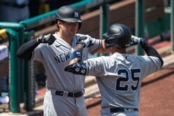 New York Yankees' Gleyber Torres (25) celebrates his solo home run with Luke Voit during the seventh inning of a game against Washington at Nationals Park, July 26, 2020.