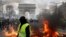 A yellow vest protester walks past a fire on Champs Elysees avenue in Paris, France, March 16, 2019.