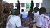 Women wait outside the packed, stuffy maternity ward of Juba's hospital, South Sudan. (H. McNeish / VOA)