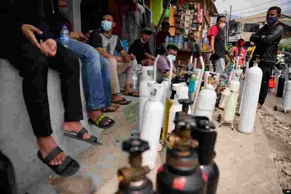 People queue to refill their oxygen tanks at a filling station in Jakarta, Indonesia.