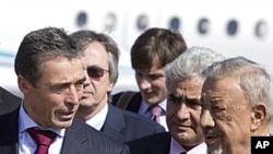 Libyan interim Defence Minister Mohammed Dfeynas (R) welcomes NATO chief Anders Fogh Rasmussen upon arrival at Tripoli airport on a surprise visit hours before NATO's air mission was due to end officially, October 31, 2011.