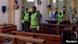 Polisi Sri Lanka memeriksa gereja St. Sebastian pasca ledakan hari Minggu (21/4). 