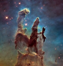 This image of the Eagle Nebula, captured by the Hubble Space Telescope, shows towers of gas and dust, known as the Pillars of Creation because within them, hundreds of new stars are being created.