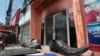 A pair of shoes lie in front of the nightclub Key Club after a fire in Chak Angre Krom village on the outskirts of Phnom Penh, Cambodia, Tuesday, Sept. 8, 2015. A large fire that apparently started in the sound mixing room engulfed the popular nightclub Monday night, an official said. (AP Photo/Heng Sinith)