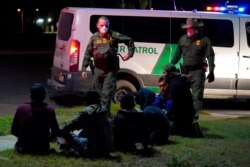 U.S. Customs and Border Protection agents take into custody people near the U.S.-Mexico border, in Hidalgo, Texas, March 20, 2021.