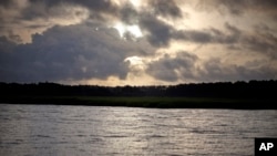 FILE - The sun rises over Sapelo Island, Georgia, a Gullah-Geechee community, June 10, 2013.