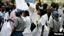 FILE - Zimbabwean riot policemen stand in front of doctors and nurses who are demonstrating over the deteriorating health system, outside Parirenyatwa group of hospitals in Harare, Nov. 18, 2008.