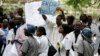 FILE - Zimbabwean riot policemen stand in front of doctors and nurses who are demonstrating over the deteriorating health system, outside Parirenyatwa group of hospitals in Harare, Nov. 18, 2008.