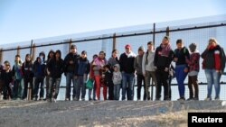 Um grupo de imigrantes centro-americanos rende-se à polícia de imigração na fronteira entre o México e os Estados Unidos. El Paso, Texas, 6 de Março, 2019.