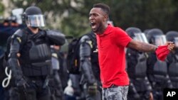 A protester yells at police in front of the Baton Rouge Police Department headquarters after police arrived in riot gear to clear protesters from the street in Baton Rouge, Louisiana, July 9, 2016. 