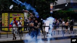 Demonstrant baca kanister sa gasom na policiju tokom demonstracija protiv reizbora predsednika Nikolasa Madura, dan nakon glasanja u Karakasu, u Venecueli, u ponedeljak, 29. jula 2024. (Foto: AP/Matias Delacroix)