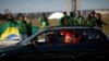 Manifestantes en una caravana de automóviles protestan contra el presidente de Brasil, Jair Bolsonaro, mientras partidarios de Bolsonaro protestan al fondo frente al Congreso Nacional. Brasilia, junio 13 de 2020.