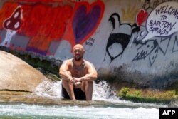 A man cools off at Barton Creek as extreme temperatures across Texas have prompted the National Weather Service to issue excessive heat warnings and heat advisories that affect more than 40 million people in Austin, Texas, on June 27, 2023.