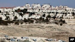 The Israeli settlement of Maaleh Adumim looms over Arab Bedouin shacks in the West Bank, Jan. 22, 2017. 