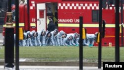 Police officers search an area of Parliament Square the morning after an attack in London, Britain, March 23, 2017. 