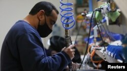 Un empleado trabaja en una fábrica de luminarias LED de alta potencia en las afueras de Buenos Aires, Argentina, 20 de julio de 2021.