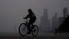 Un ciclista avanza por la ribera del lago Michigan en Chicago bajo una bruma causada por los incendios forestales en Canadá el 27 de junio de 2023.
