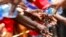 FILE - School children wash their hands during an activity to mark Global Handwashing Day at Thirime primary school in Kikuyu, near Kenya's capital Nairobi.