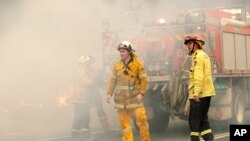 A firefighting crew battles a fire near Burrill Lake, Australia, Jan. 5, 2020. 