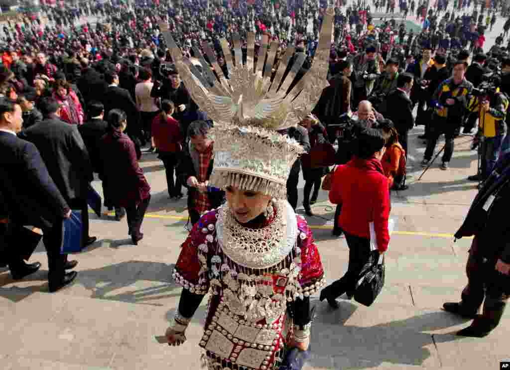 A female Ethnic minority delegate walks from the Great Hall of the People after attending the opening session of the National People's Congress in Beijing, March 5, 2013. 