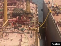 Technicians work on the deck of the replacement vessel as the transfer of oil from the decaying FSO Safer oil tanker began off Yemen July 25, 2023. (United Nations/David Gressly/Handout via REUTERS)